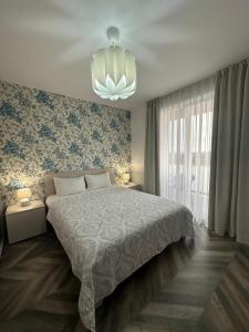 a bedroom with a large bed and a chandelier at Vivo Residence II in Baia Mare