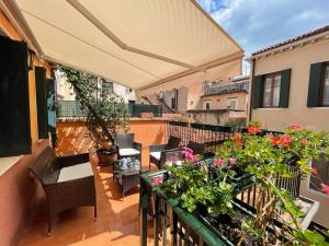 un balcon avec des chaises et des fleurs sur un immeuble dans l'établissement San Marco Luxury apartments Muneghe, à Venise