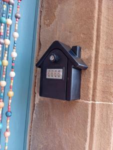 a black mailbox on the side of a wall at appartement hôtes entier Millau Compeyre in Compeyre