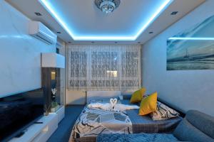 a room with a bed and a couch and a tv at Lux Mila with Free Private parking in Novi Sad
