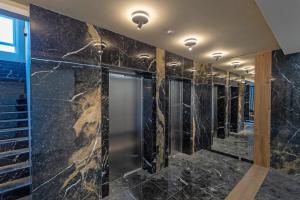 a walk in shower with black marble walls at Lux Mila with Free Private parking in Novi Sad +24 photos