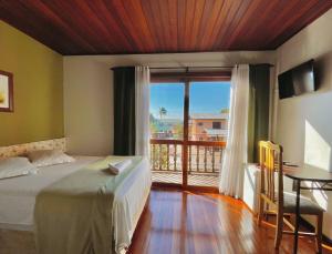 a bedroom with a bed and a window and a desk at Sonho da Serra Pousada in Bento Gonçalves
