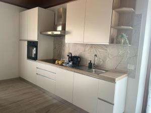 a kitchen with white cabinets and a sink at Appartamento sul Lago - MEINA in Meina