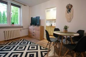 a living room with a table and chairs and a television at Apartament Na Parterze in Lesko