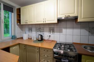 a kitchen with white cabinets and a stove top oven at Apartament Na Parterze in Lesko