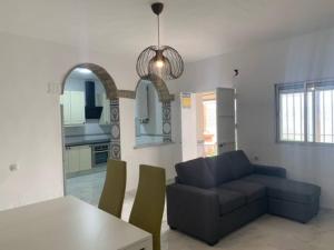 a living room with a couch and a table at Chalet a 2 metros de la playa in Rota