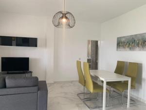 a living room with a table and yellow chairs at Chalet a 2 metros de la playa in Rota