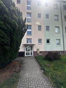 a building with a brick walkway in front of it at 3-Zimmer Ferienunterkunft inkl Parkplatz und Balkon, mit Nähe zum See in Rüdersdorf