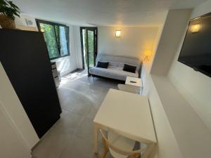a living room with a table and a couch at Studio neuf rez de jardin dans chalet individuel in Thollon