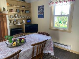a dining room table with a bowl of fruit on it at Historic Hillside Vacation Home in Twillingate