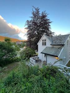 a small white house with a porch in a yard at Villa Nostalgia in Bergen