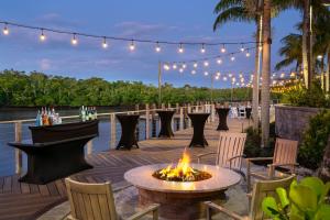 a fire pit on a deck with chairs and lights at Hyatt House Naples 5th Avenue in Naples