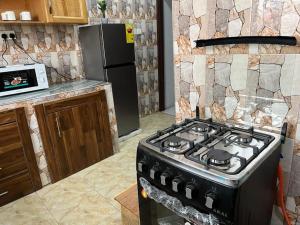 a kitchen with a stove top oven in a kitchen at Large Stylish 2 Bedroom Flat in Kumasi