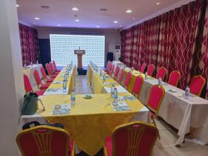 a conference room with long tables and chairs and a podium at Airport West Hotel in Accra