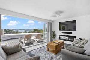 a living room with a fireplace and a large window at Vomero Holiday Apartments in Torquay