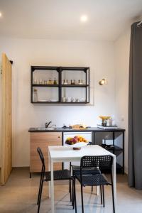 a kitchen with a white table and chairs and a counter at MamErì central rooms in Castellammare del Golfo +8 photos