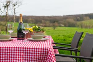 龙塞Boerderij63的桌子上有一瓶酒和两个酒杯
