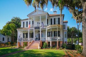 a large white house with palm trees at Cuthbert House in Beaufort