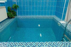 a blue tiled bath tub with a blue tiled floor at Astana International Hotel in Almaty