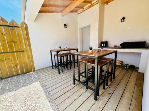 two tables and chairs on a balcony with a kitchen at Villas Oléron à 50m de la plage in La Brée-les-Bains +24 photos