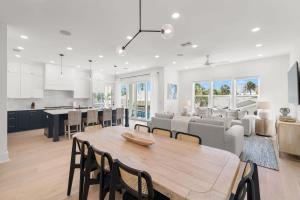 Una cocina y una sala de estar con una mesa y sillas de madera. en Akoya House at The Gemma by Brightwild, en Clearwater Beach