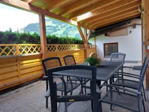 a black table and chairs on a patio at Landhaus Irena - Familienfreundliches Ferienhaus an der Zillerpromenade mit Bergblick in Ramsau im Zillertal