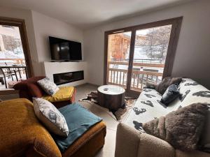 a living room with a couch and a table at Résidence Le Solea - APPARTEMENT CHALEUREUX SPA/SAUNA-Tout inclus MAE-5871 in Vars