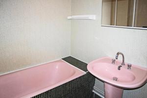a bathroom with a pink tub and a sink at Résidence La Mazeliere - 26 MAZELIERE LES ORRES 1650 MAE-3644 in Le Mélézet