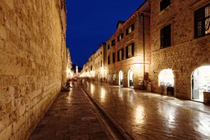 an empty street in an old town at night at Apartments Eleganca, crypto payment accepted in Dubrovnik