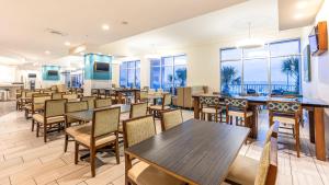 a dining room with tables and chairs and windows at Holiday Inn Express & Suites Panama City Beach - Beachfront by IHG in Panama City Beach