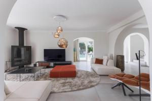 a living room with a couch and a tv at Villa GALET in Saint Paul de Vence