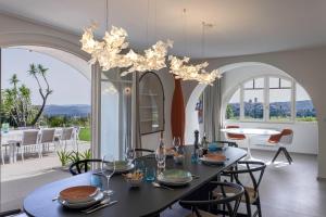 a dining room with a table and a chandelier at Villa GALET in Saint Paul de Vence