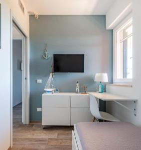 una camera da letto con una scrivania e una TV a parete di Maison Costa del Sol - Capitolo, Monopoli a Monopoli