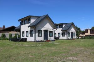 una gran casa blanca con patio en Domki Bukowy Las, en Rewa