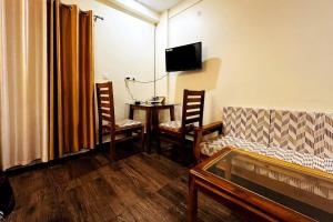 a living room with a couch and a table with chairs at Vista Casita Ranikhet Serene Homestay Himalaya Lap in Rānīkhet