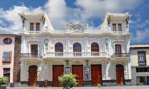 un edificio blanco con puertas rojas en una calle en Apartamento La Higuera, en La Laguna