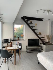 雅莱La petite Sartoise的一间有床、桌子和电视的房间