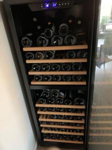 ein Weinschrank mit vielen Weinflaschen gefüllt in der Unterkunft Home in Paris in Sèvres