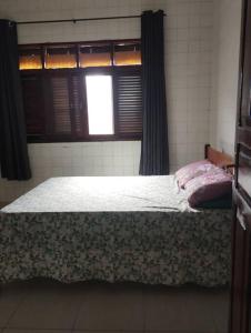 ein Schlafzimmer mit einem großen Bett mit Fenster in der Unterkunft Casa de Vó in Campina Grande