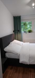 a bedroom with a bed with white sheets and a window at Rumia Cichy Zaułek 4 in Rumia