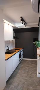 a kitchen with white cabinets and a sink at Rumia Cichy Zaułek 4 in Rumia