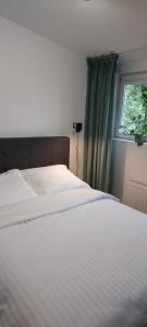 a white bed in a bedroom with a window at Rumia Cichy Zaułek 4 in Rumia +13 photos