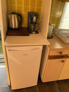 a kitchen with a counter with a refrigerator and a microwave at Przyczepa holenderska domek I in Przemysław