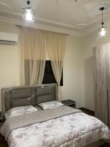 a bedroom with a bed and a window with curtains at شقق مفروشه للايجار اليومي بالطائف in Al Ḩawīyah