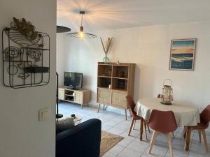a living room with a table and a dining room at Le petit coin de Joe Détente Proche Centre bassin in Le Teich