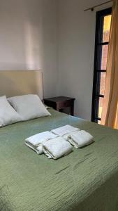 zwei Handtücher auf einem grünen Bett in der Unterkunft Hermoso Departamento Familiar y Tranquilo in Santa Fe