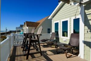 eine Terrasse mit Stühlen und Tischen auf einem Haus in der Unterkunft Sweet M'Ocean in Thomas Landing