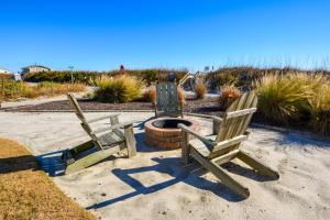 drei Holzstühle neben einer Feuerstelle in der Unterkunft Sweet M'Ocean in Thomas Landing