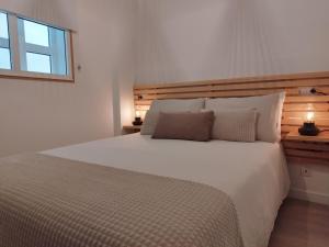 a bedroom with a large white bed with a window at AnnaChic in Ribeira