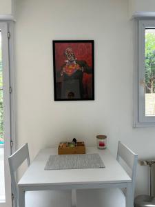 a white dining room table with a picture on the wall at La Pléiade Dorée - Extra Centre - Wifi HD - Terrasse & Jardin in Amiens
